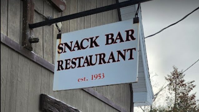 Snack Bar Restaurant sign hanging on front of the building.