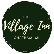The Village Inn Logo on an olive green circle.